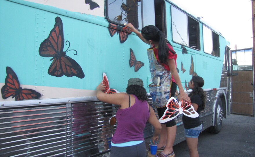 Activists paint the vintage bus they plan to drive across the South to protest deportations.