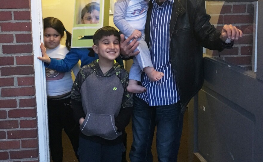 Omar Al-Awad stands with his four children in their apartment complex in Toledo.
