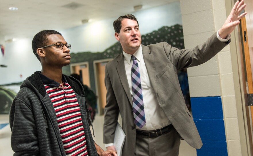 Principal Charles Gregory (right) asks Robert Gordon to watch students in the middle school hallway during class change.