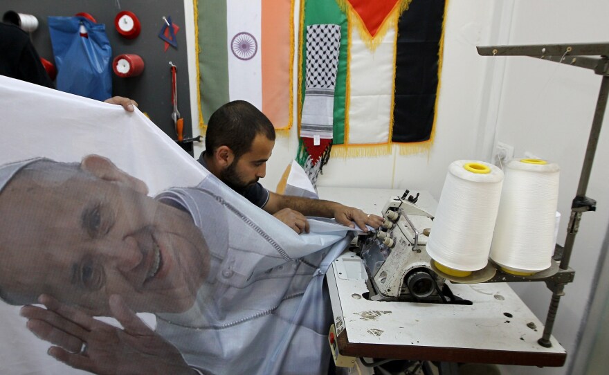 A Palestinian man works on a banner bearing a portrait of Pope Francis at printing house in the West Bank city of Ramallah in anticipation of his Middle East visit this week.