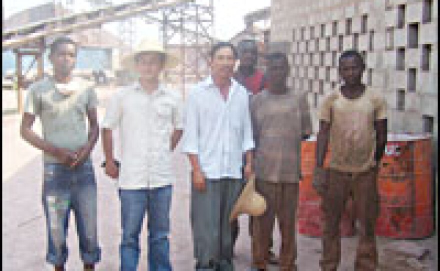 A Chinese foreman poses with his Congolese laborers. The Chinese construction company pays the Congolese laborers just 35 cents an hour for their work at the quarry.