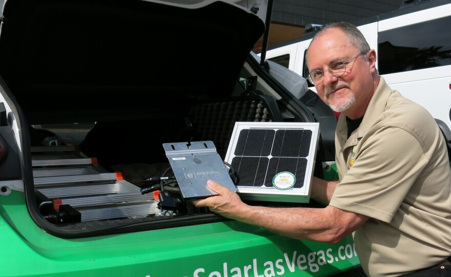 Robco Electric Sales and Marketing Manager Tim Webb shows off a solar panel from his sales kit. Since regulators have phased out solar incentives, his car often sits in the company parking lot.