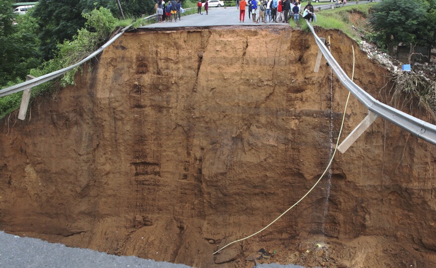 Stranded people stand in front of a bridge that was swept away in Ntuzuma, outside Durban, South Africa, on Tuesday.