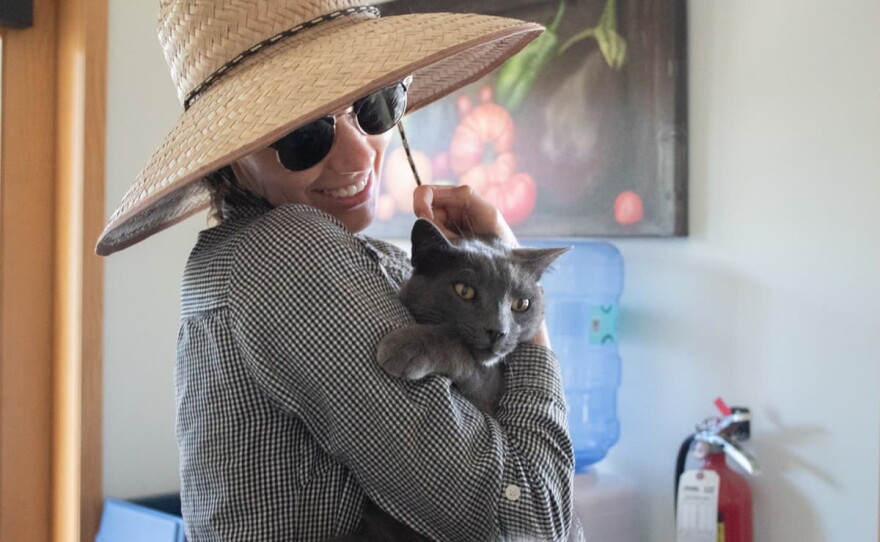 Farm and Climate Program Director Delaney Sondag holds the farm’s resident mouser “Gray Kitty” Thursday, July 30, 2026, in Woodland. Sondag says his name is legally Buddy, but no one calls him that.