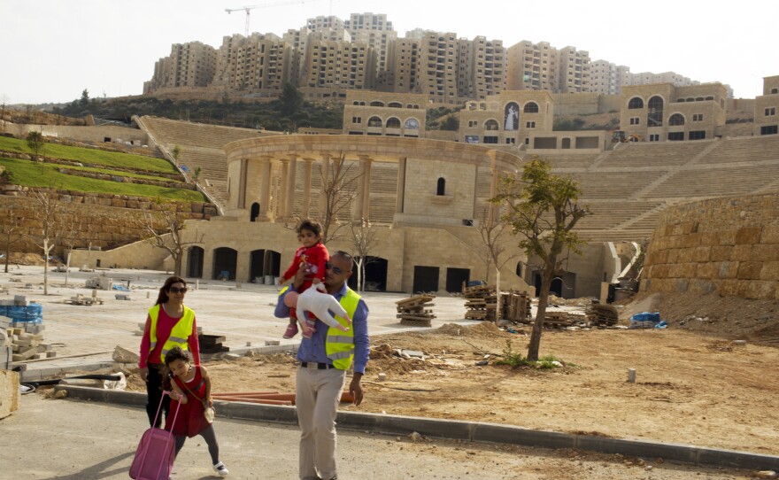 A Palestinian couple walks by an amphitheater under construction in Rawabi, a Palestinian real estate development in the West Bank. The couple lives nearby in East Jerusalem and says they are looking to buy in Rawabi as an investment or as a vacation home.