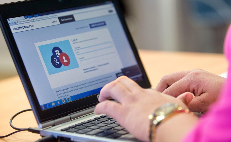 A guide works on the federal enrollment website as she helps a Delaware resident sign up for coverage under the Affordable Care Act in 2014.