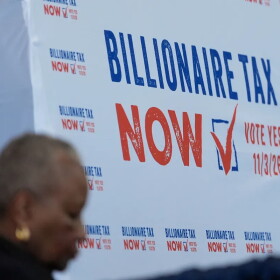 A sign displayed at the Billionaire Tax Now booth at the 2026 California Democratic Party State Convention in San Francisco on Feb. 21, 2026.