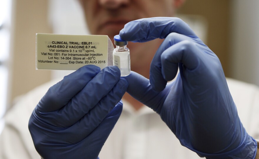 Adrian Hill, director of the Jenner Institute and chief investigator of the trials with an Ebola vaccine his organization developed, holds a vial of the vaccine.