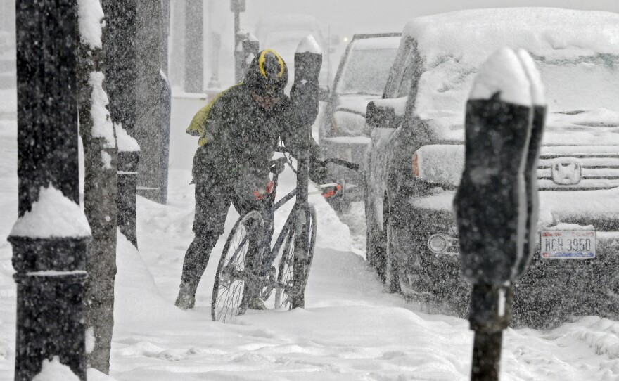 A bicycle messenger struggles through the snow in downtown Cleveland on Friday.