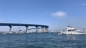 A boat drives away from the Coronado Bridge, July 3, 2021.