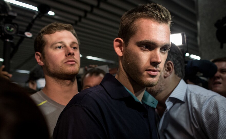 U.S. Olympic swimmers Gunnar Bentz and Jack Conger leave the police headquarters at Rio de Janiero's international airport on Thursday.