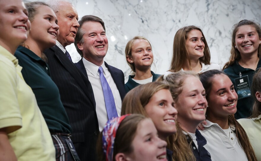 Supreme Court nominee Judge Brett Kavanaugh poses for photos with young basketball players he has coached, during a break in his Senate Judiciary Committee hearings Thursday.