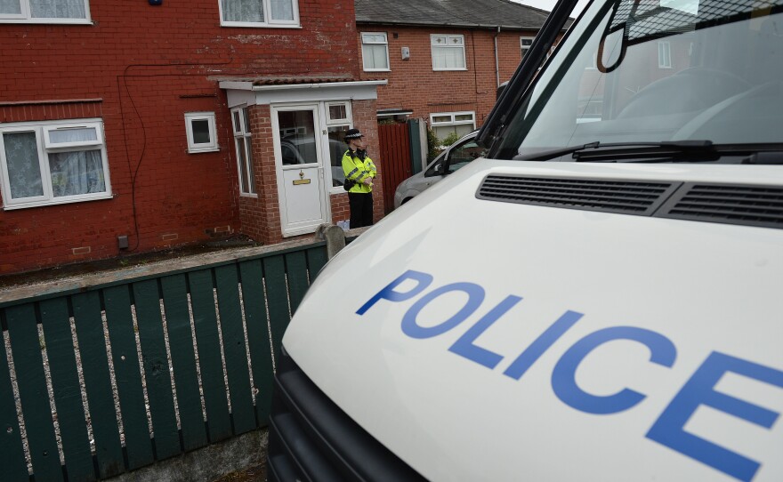 A police officer stands on duty outside a residential property in Fallowfield, in southern Manchester, on Wednesday as investigations continue into the bombing at the Manchester Arena.