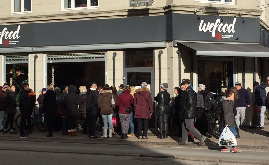 A crowd waits on the sidewalk for the WeFood grocery store in Copenhagen to open. It's not the first grocer in Europe to sell surplus food. But unlike so-called "social supermarkets" – stores which serve almost exclusively low-income people — WeFood's offerings are very intentionally aimed at the general public.