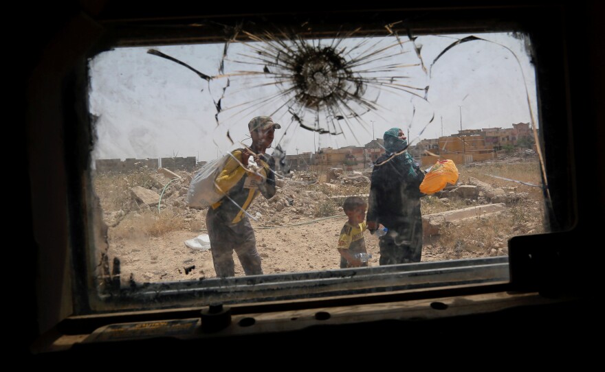 Displaced Iraqis flee during a fight between Iraqi counterterrorism service forces and Islamic State militants in western Mosul, Iraq, on May 15, 2017.