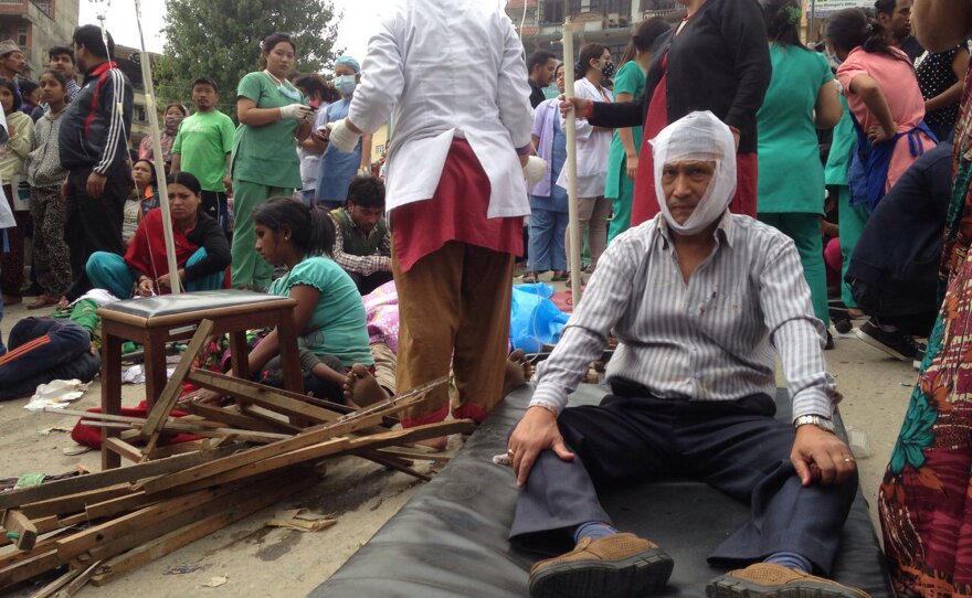 Injured people receive treatment outside the Medicare Hospital in Kathmandu, Nepal, on Saturday.