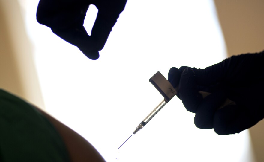 A droplet falls from a syringe after a health care worker was injected with the Pfizer-BioNTech COVID-19 vaccine at Women & Infants Hospital in Providence, R.I.