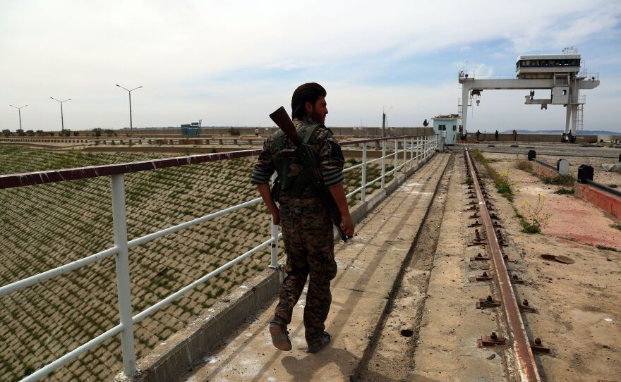 Central Command says an errant coalition strike killed 18 fighters from the Syria Democratic Forces. A member of the U.S.-backed SDF, made up of an alliance of Arab and Kurdish fighters, inspect the Tabqa dam on March 27.