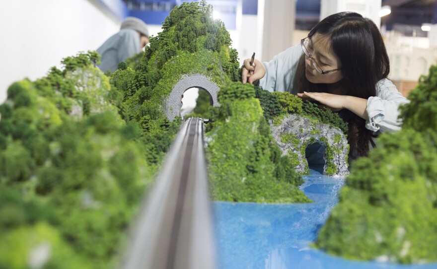 Model maker Yu-ting Ling works on part of the Gulliver's Gate Asia display.