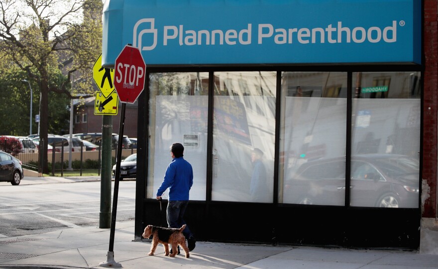 A person walks by a Planned Parenthood clinic on May 18, 2018 in Chicago. Under the new rule, posted Friday by the federal Department of Health and Human Services Office of Population Affairs, any organization that provides or refers patients for abortions is ineligible for Title X funding to cover STD prevention, cancer screenings and contraception.