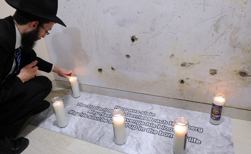 Rabbi Israel Kozlovsky, the new director of Nariman House in Mumbai, lights a candle Tuesday at the spot where his predecessor, Rabbi Gavriel Holtzberg, was killed during a 2008 attack.