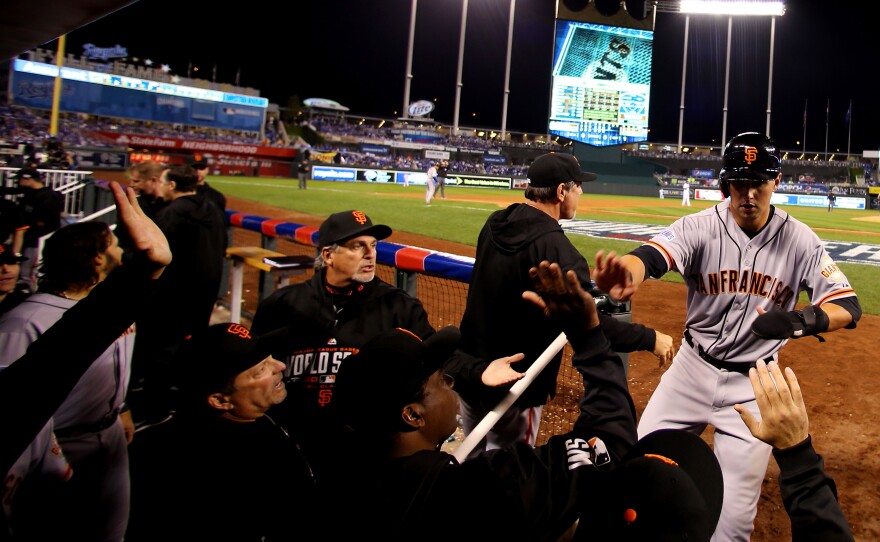 Microphones line the dugout, catching the sound of celebrations like this one by the Giants, after second baseman Joe Panik's seventh-inning score in Game 1.