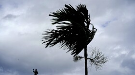 A man stands on a store's roof as he works to prepare it for the arrival of Hurricane Dorian in Freeport on Grand Bahama, Bahamas, Sept. 1, 2019.