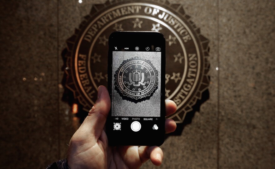 The official seal of the Federal Bureau of Investigation is seen on an iPhone's camera screen outside the J. Edgar Hoover headquarters in Washington, D.C. Apple is facing off with the FBI in court over investigators' request that the tech giant help them circumvent the iPhone's security features.