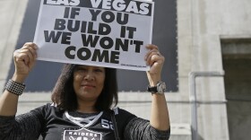 Monette Bonilla, of San Jose, Calif., holds up a sign outside the Oakland Coliseum before the start of a rally to keep the Oakland Raiders from moving Saturday, March 25, 2017. 