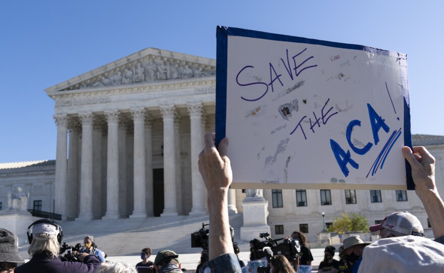 A demonstrator holds a sign in support of the Affordable Care Act in front of the U.S. Supreme Court last November. On Thursday, the justices did just that.