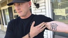 Brendan Kelly speaks with reporters outside his home, as he shows his Route 91 tattoo, Thursday, Nov. 8, 2018, in Thousand Oaks, Calif.