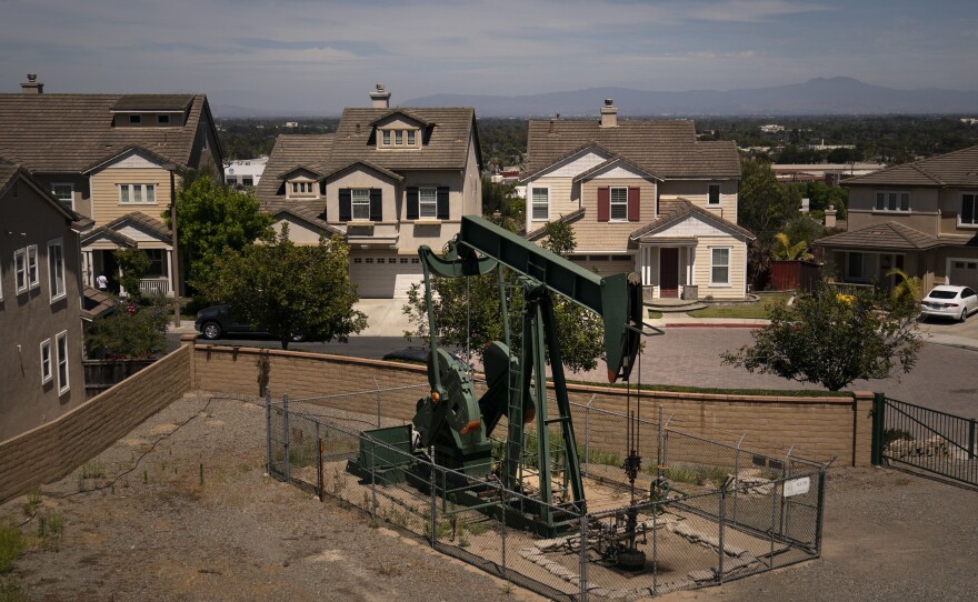A pump jack extracts oil at a drilling site next to homes on June 9, 2021, in Signal Hill, Calif.