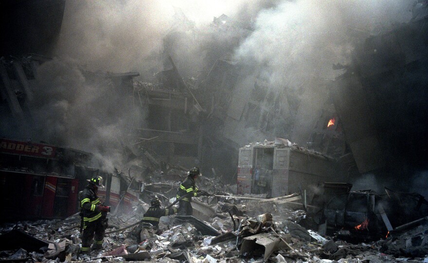 Firemen begin the long work of cleaning up the rubble of the North Bridge and the World Trade Center buildings.