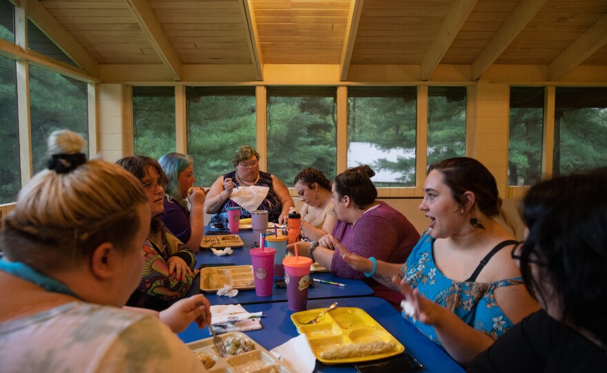 Campers chat over dinner in the main cabin at Camp Roundup, a body positivity and acceptance camp for women that took place Labor Day weekend in Newark, Ohio.