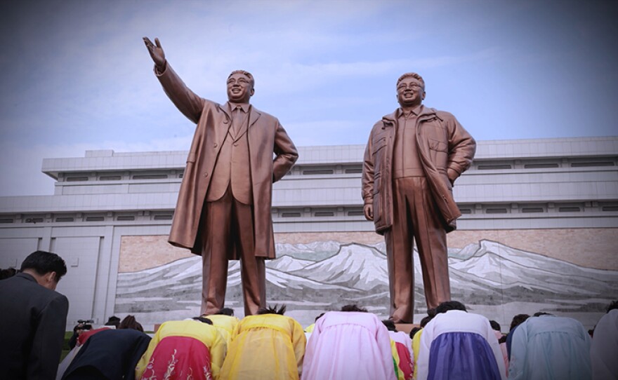 North Koreans bow in front of statues of Kim Il Sung and successor, his son Kim Jong Il. Pyongyang, 2015.