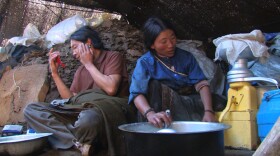 Yama churns butter as Locho attends to his skin care regimen, Zachukha, in eastern Tibet.