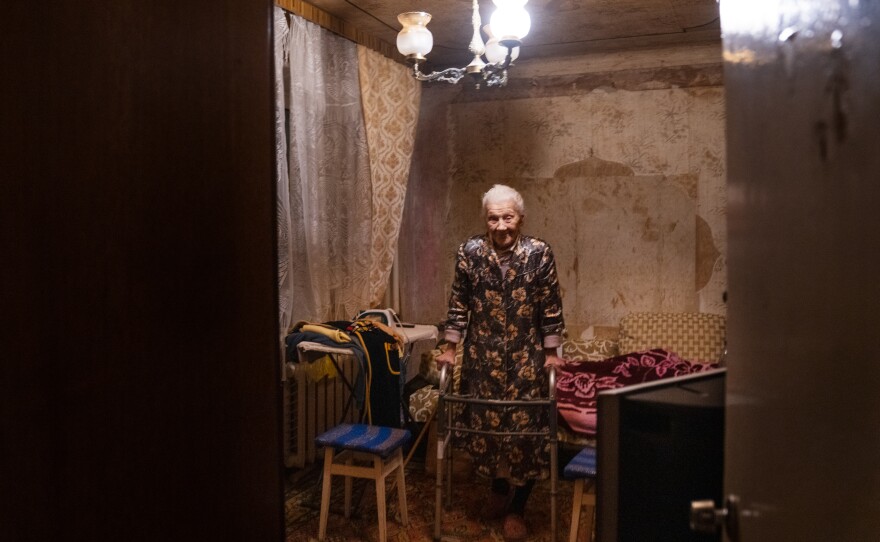 Nadiia Yerkhimovych stands with the help of a walker in her home.