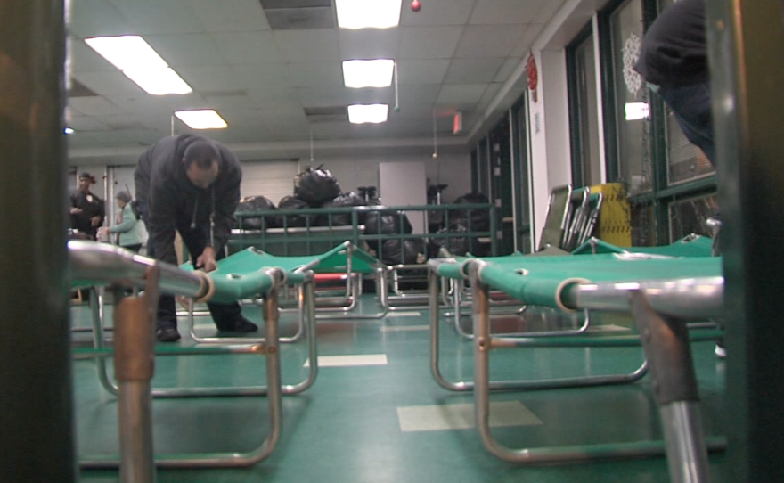 Staff members set up cots in the cafeteria at St. Vincent De Paul Village, Dec. 28, 2015.