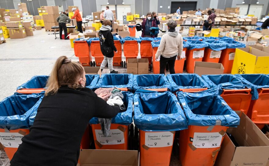 Volunteers from the aid organization "Borderless Warmth" sort relief supplies for Ukraine at the Westfalenhalle in Dortmund, western Germany.