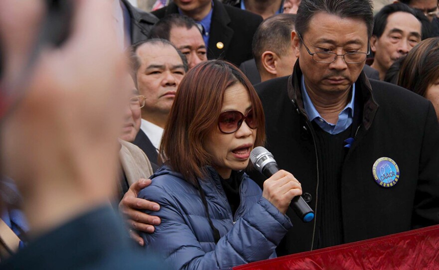 Peter Liang's mother speaks at the Feb. 20, 2016 protest in support of her son at Cadman Plaza in Brooklyn, N.Y. while John Chan offers support.