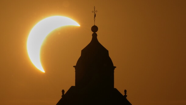 A solar eclipse is seen over a Virgin Maria church in Vidigulfo, near Pavia, northern Italy, Wednesday, Aug. 12, 2026.