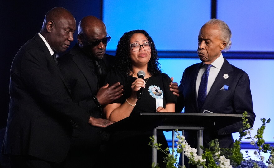 Christine Wonsley, center, is flanked by her husband Elmore, second from left, attorney Ben Crump, left, and Rev, Al Sharpton, right, during a memorial service for her son Nolan Xavier Wells, an 18-year-old found dead after taking a July 4 boat trip with friends, Monday, July 20, 2026, in Ocean Springs, Miss.