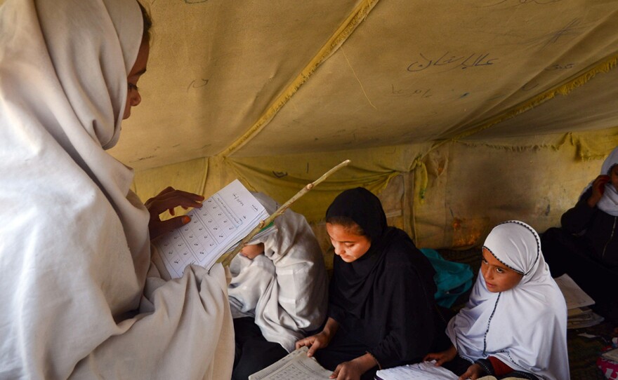 Afghan students attend an under tent class in Jalalabad, capital of Nangarhar province, Afghanistan, Dec. 16, 2015.