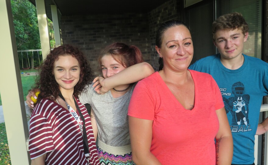 Daisy Hohman stands with her three children. She says the last bill she got from Wright County says she still owes more than $7,000 for foster care.