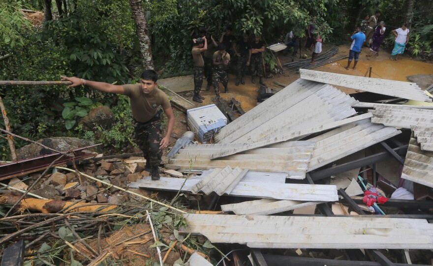 A Sri Lankan army soldier walks on the debris of a house during a search operation in Elangapitiya village in Aranayake, some 45 miles north of Colombo, Sri Lanka, on Thursday.