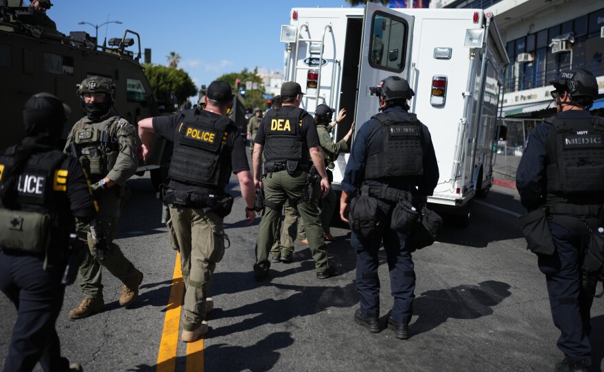 Drug Enforcement Administration (DEA) agents alongside other law enforcement officers work the scene near MacArthur Park after federal authorities made arrests on charges related to selling illicit drugs on Wednesday, May 6, 2026, in Los Angeles.