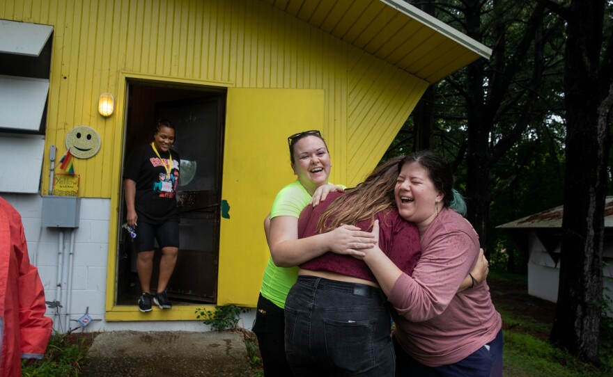 Mary Yale and Kylie Davis hug their counselor, Cat Ruehlman, before they leave Camp Roundup on Sept. 5 in Newark, Ohio.