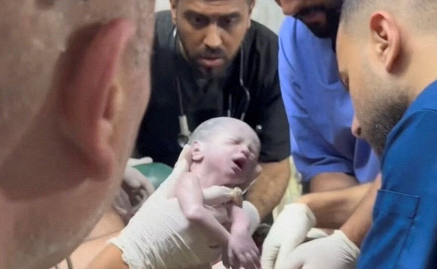 A medic holds a newborn girl after she was delivered via cesarean section at a hospital in Rafah in the southern Gaza Strip, in this still image taken from a video recorded April 20.