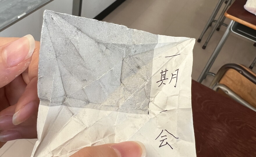 The message inside the crane from her unsung hero. Roughly translated, it means "cherish the moment."