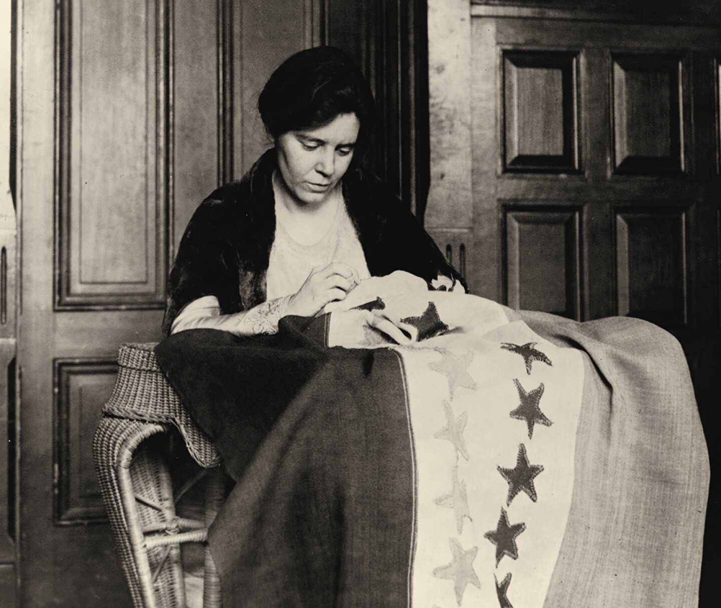 Alice Paul sews stars on flag marking state ratifications. Washington, D.C., 1920.